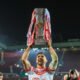 Tommy Makinson lifts the Super League trophy aloft at Old Trafford, playing for St Helens.