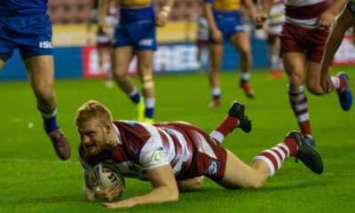 Joe Bulloock, in Wigan's cherry-and-white, dives to score a try. He now plays for Hull FC on loan.