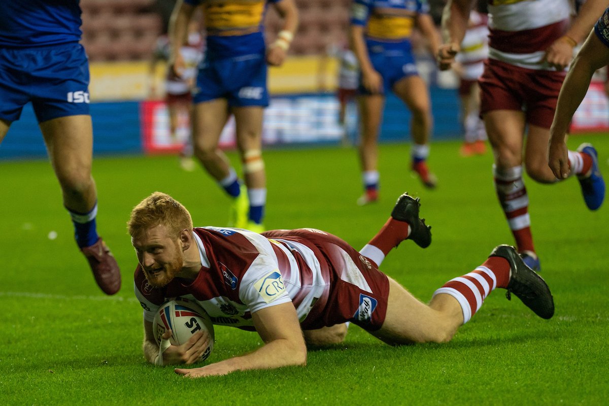 Joe Bulloock, in Wigan's cherry-and-white, dives to score a try. He now plays for Hull FC on loan.