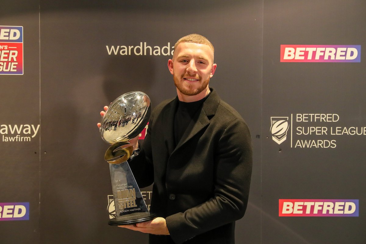 Jackson Hastings holds the Man of Steel trophy, wearing all-black attire.