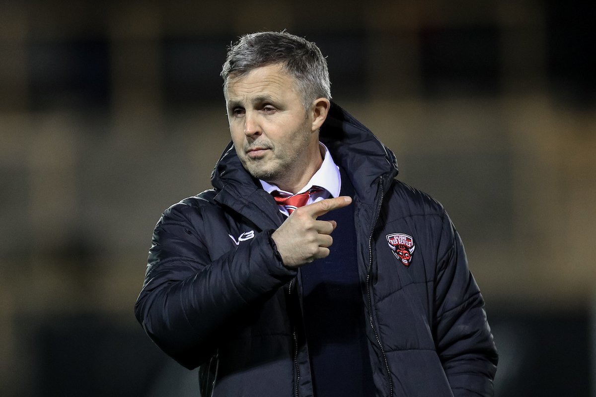 Paul Rowley Head Coach of Salford Red Devils stands on the field with his players ahead of the game
