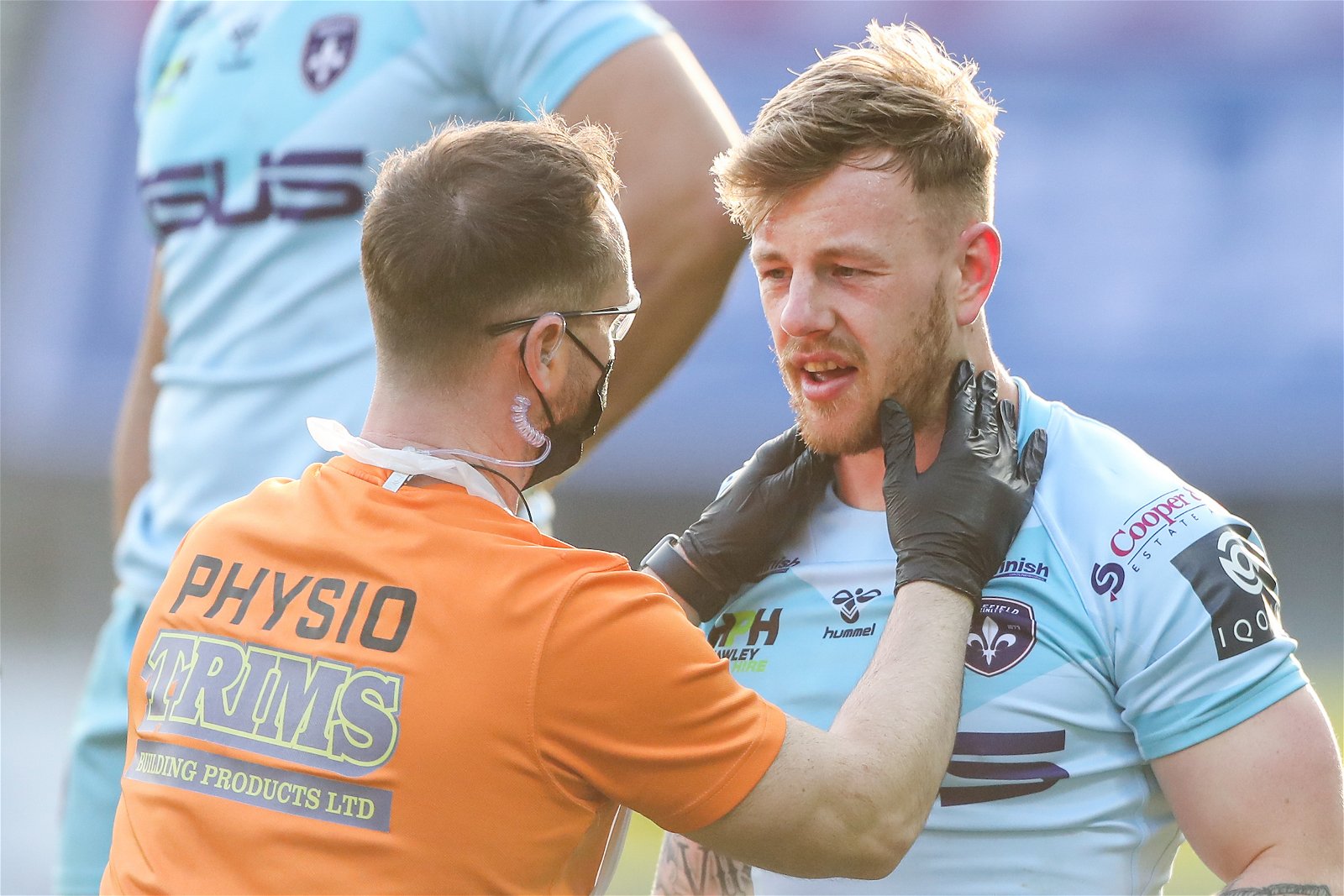 Tom Johnstone, playing for Wakefield Trinity, is treated by a physio in Super League action against Wigan Warriors.