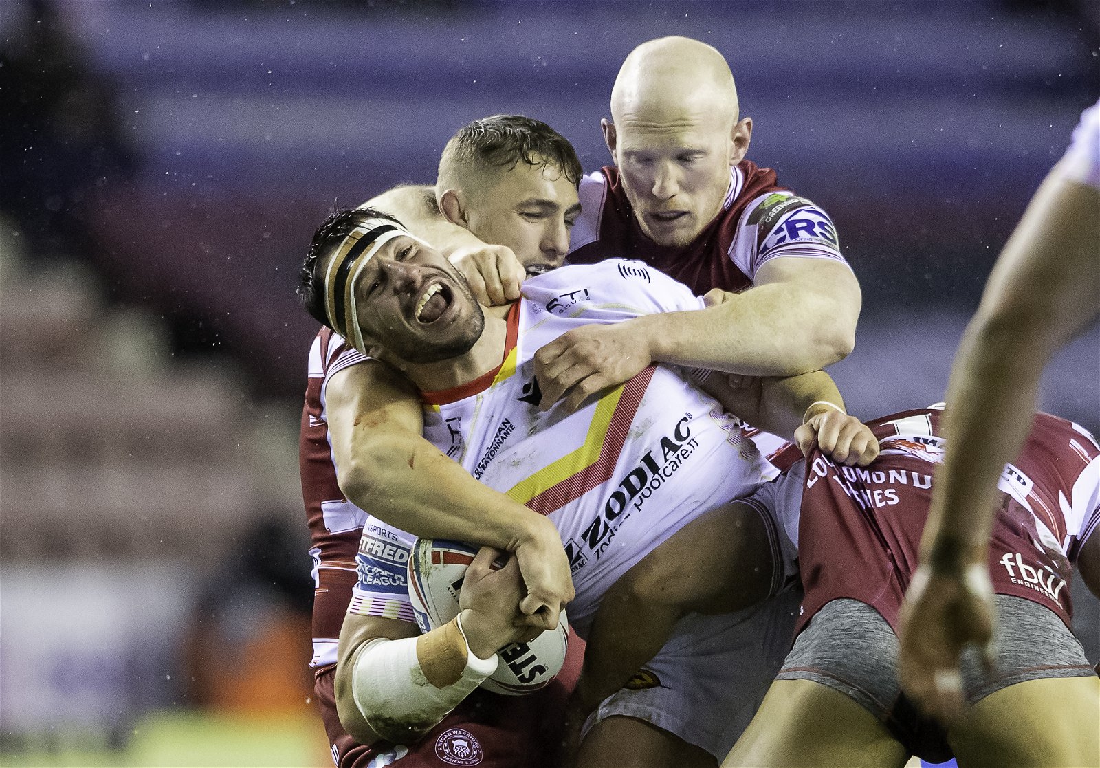 Catalans' Benjamin Garcia is tackled by Wigan's Liam Farrell and Sam Powell in the Super League.