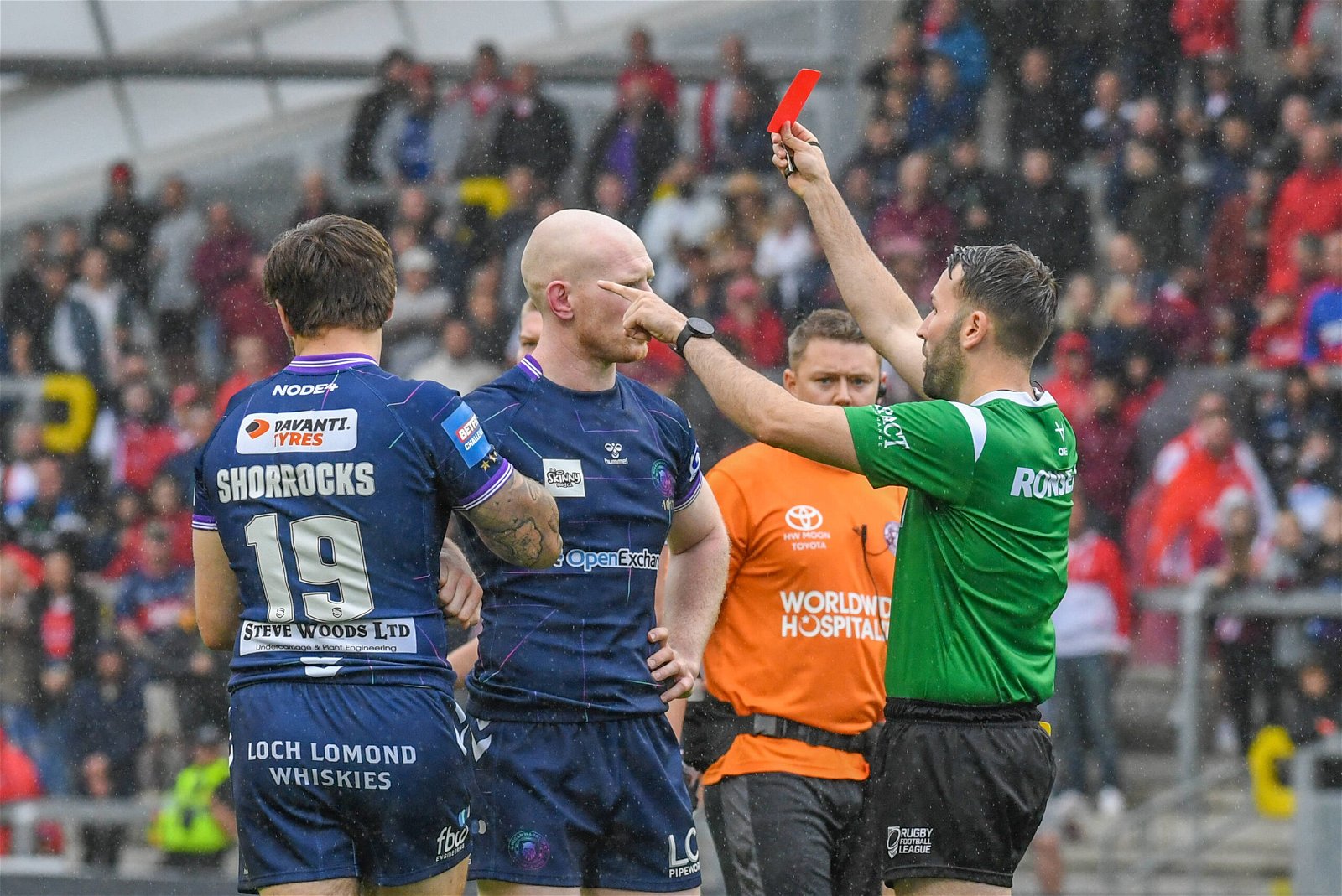 Liam Moore, in Super League referee gear, gives Wigan's exasperated Joel Shorrocks a red card.