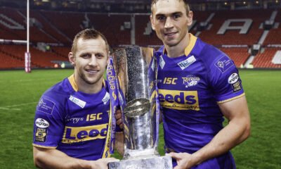 Rob Burrow and Kevin Sinfield hold the Super League trophy in the corner of an empty Old Trafford stadium.
