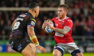 Marc Sneyd, playing for Salford, runs with ball in hand, looking to evade a defender. He leads the Man of Steel standings.