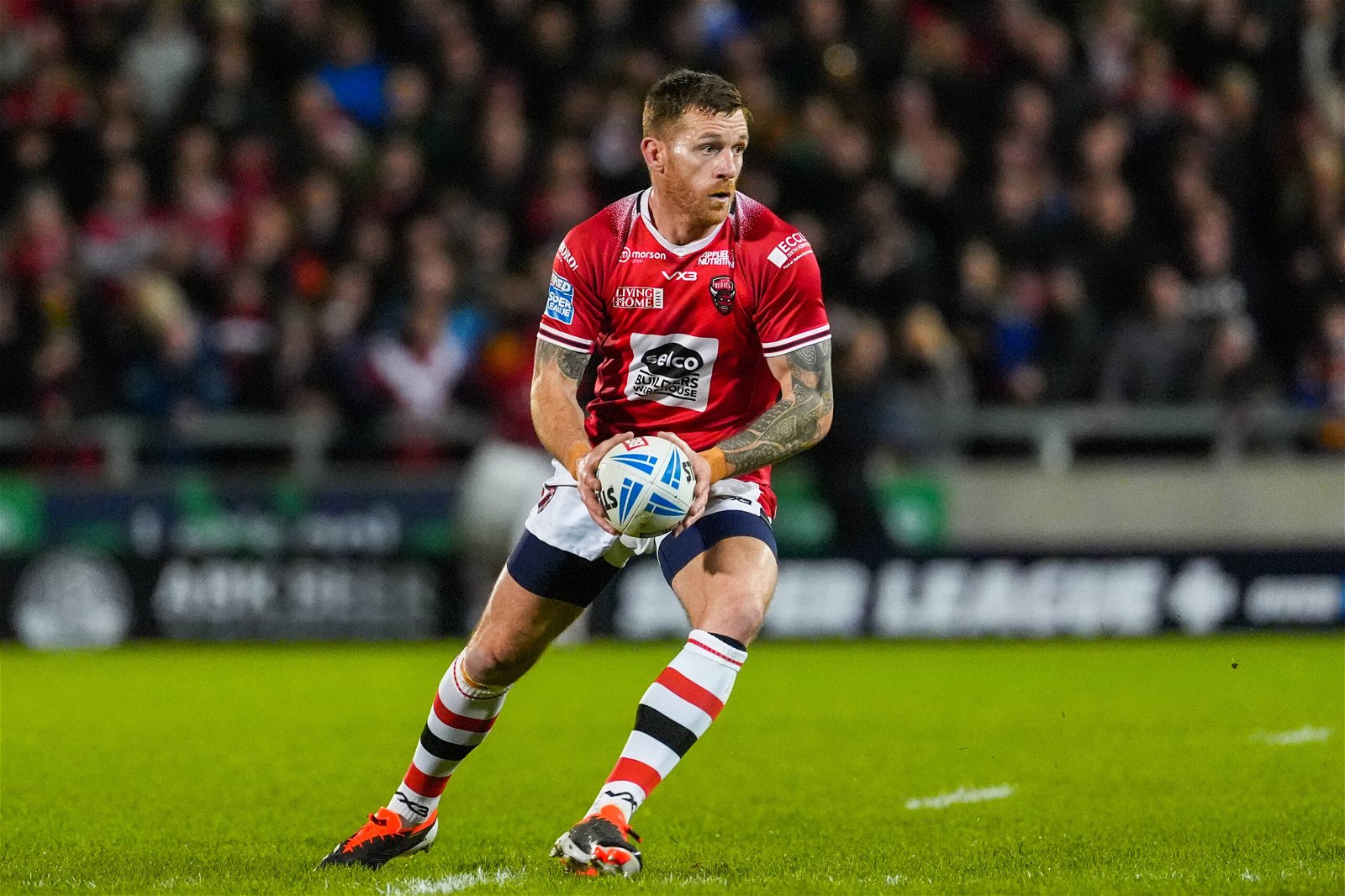 Marc Sneyd, playing for Salford, holds the ball. He tops the Man of Steel rankings