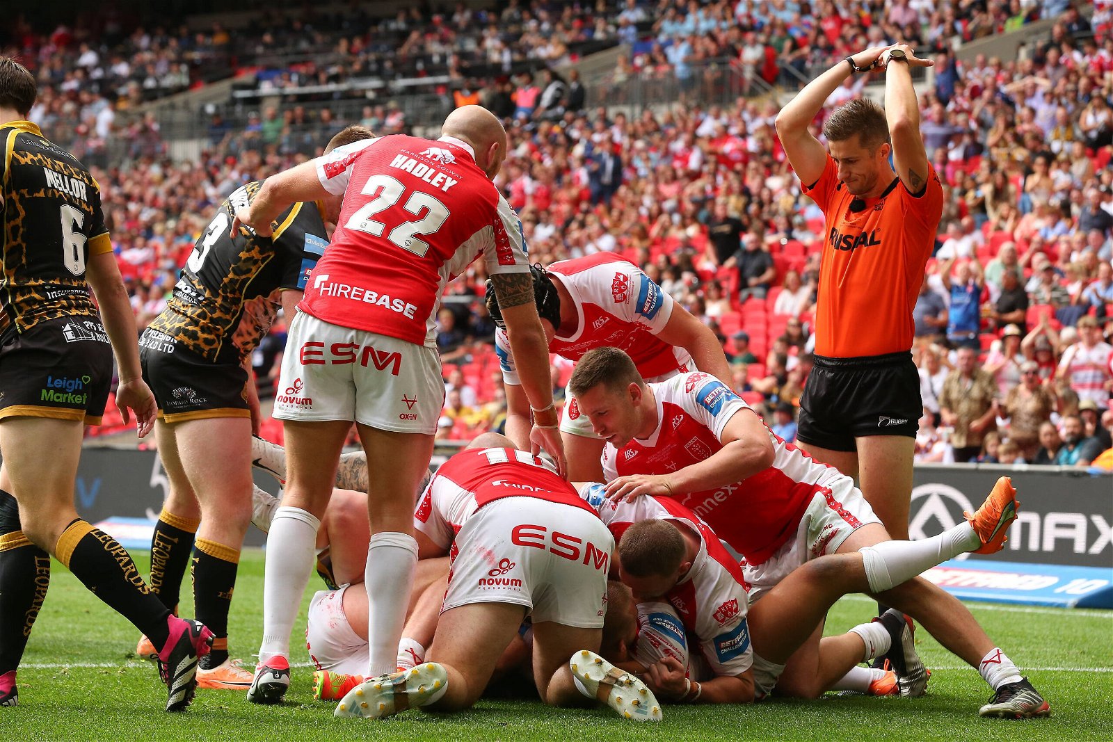 Hull KR players hold a Leigh Leopards player up after he crosses the line during the Challenge Cup Final at Wembley Stadium. 