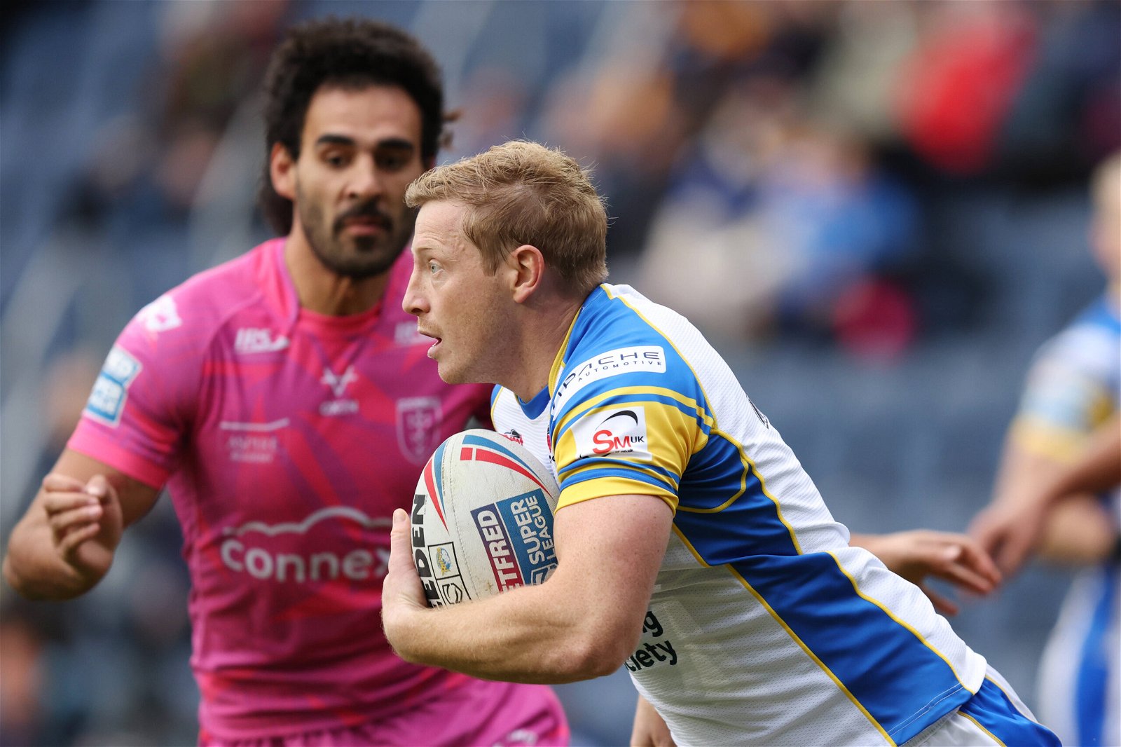 Leeds Rhinos' Lachlan Miller holds off a defender in Super League action against Hull KR