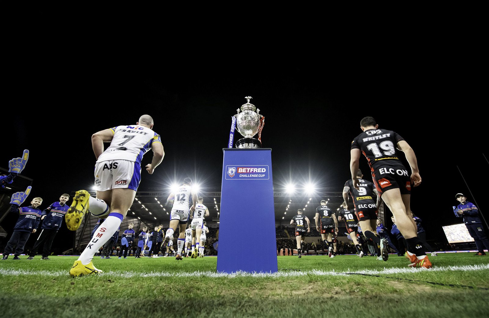 Leeds Rhinos and St Helens come out to the field of play past the Betfred Challenge Cup trophy at Headingley