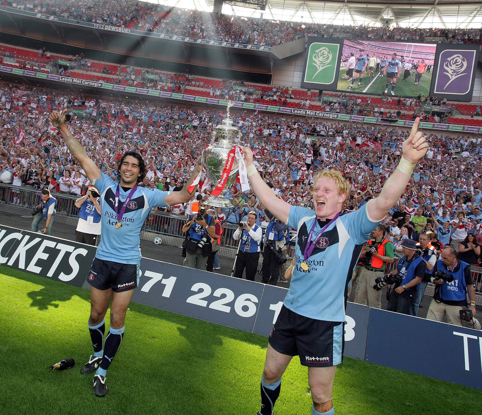 St. Helens Ade Gardner and James Graham celebrate with the trophy in front of fans