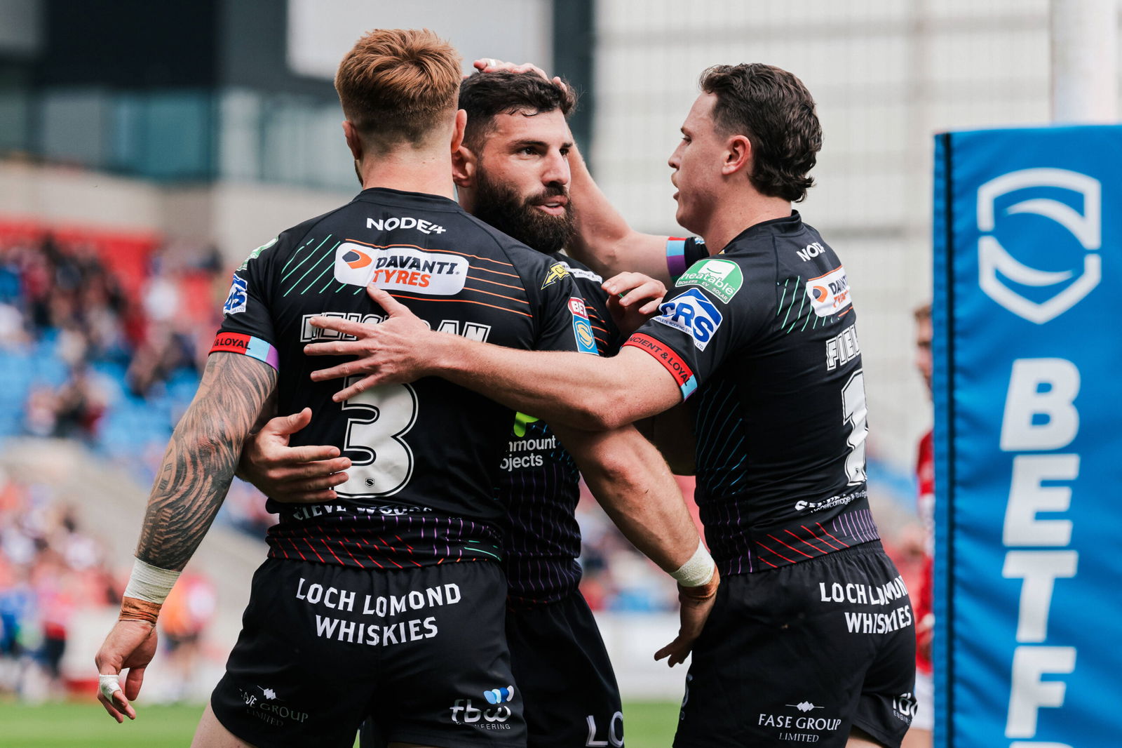 Wigan Warriors - Salford Community Stadium, Eccles, England - Wigan's Adam Keighran celebrates with Abbas Miski and Jai Field after scoring a try