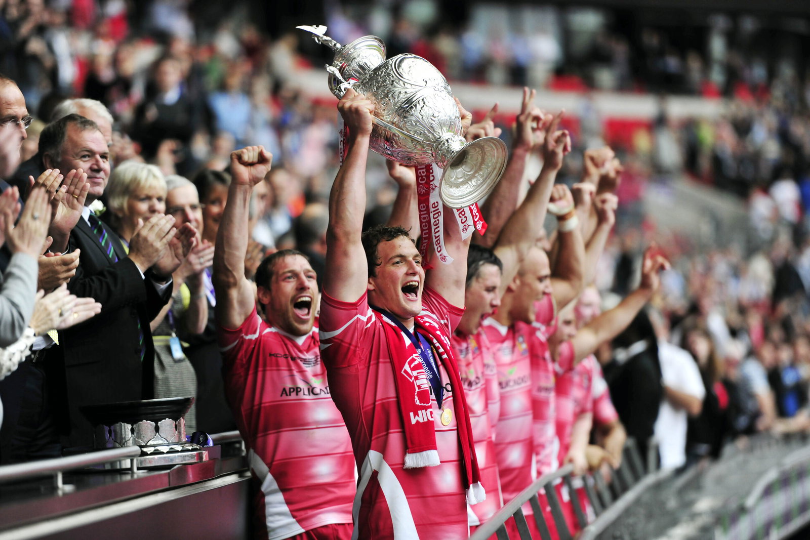 Wigan captain Sean O'Loughlin lifts the challenge cup.