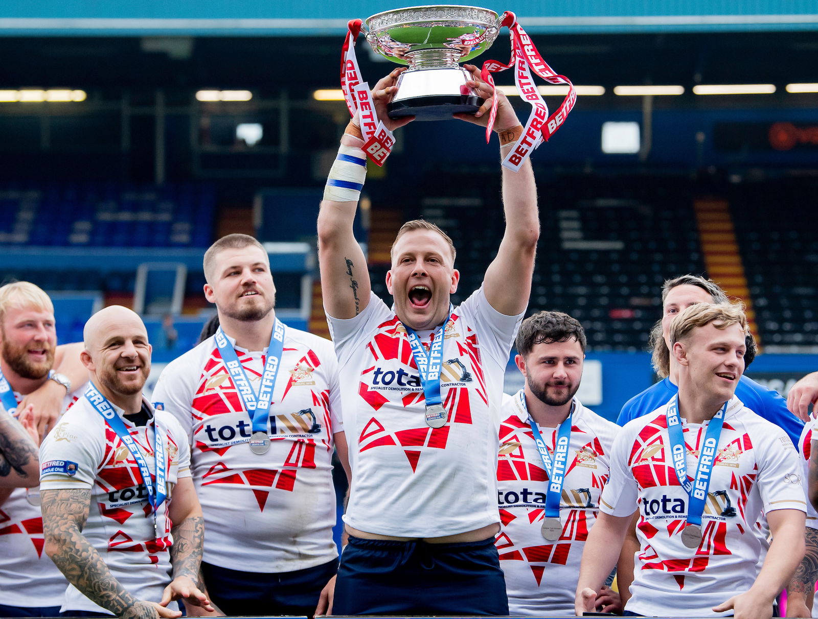 - 01/09/2024 - Rugby League - Betfred League 1 Round 23 - Oldham Roughyeds v Workington Town - Vestacare Stadium, Oldham, England - Oldham's Craig Kopczak lifts the Betfred League 1 trophy after his side's victory over Workington Town.