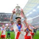Hull KR captain Elliot Minchella lifting the Challenge Cup trophy